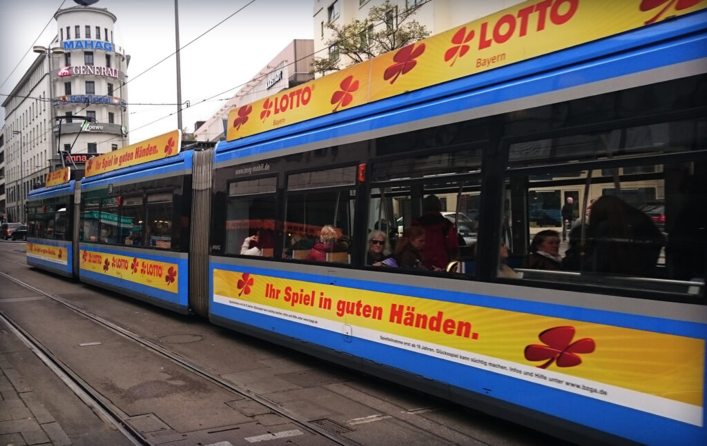 Verkehrsmittelwerbung 10 Straßenbahnwerbung mit Dachschild und Rumpfwerbung (Kampagne Lotto)